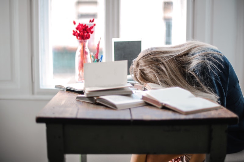 A woman in stress while reading multiple books