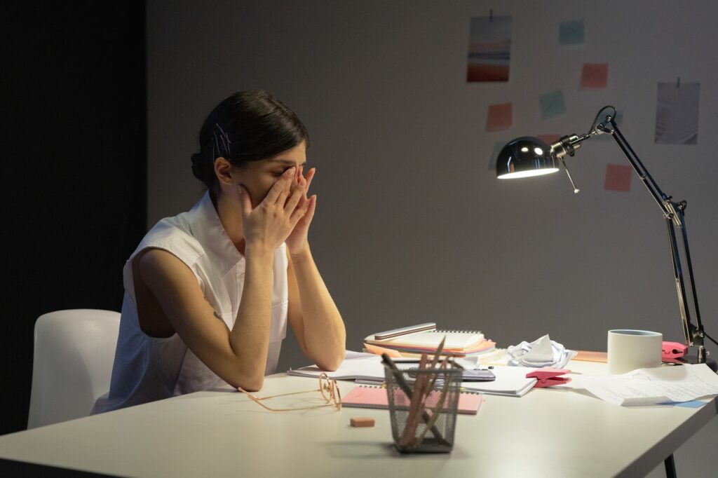 Woman stressed while working late at desk.