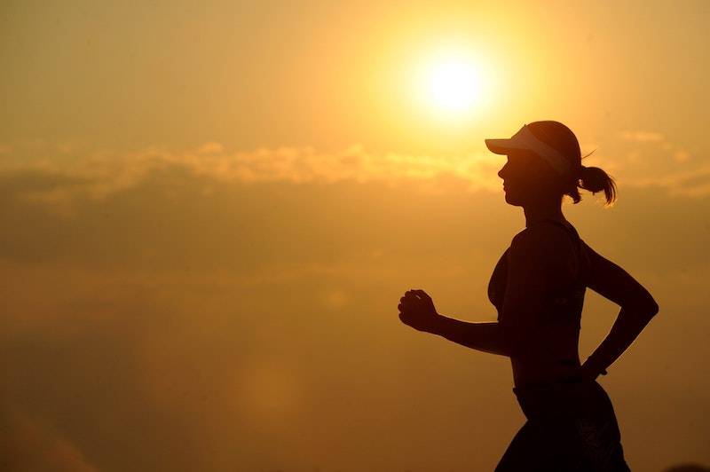 A silhouette of a woman jogging