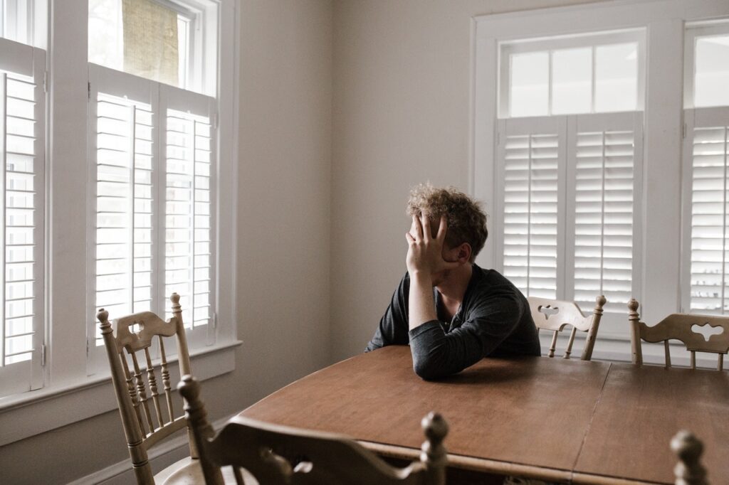 A man sitting at a table in front of a window.