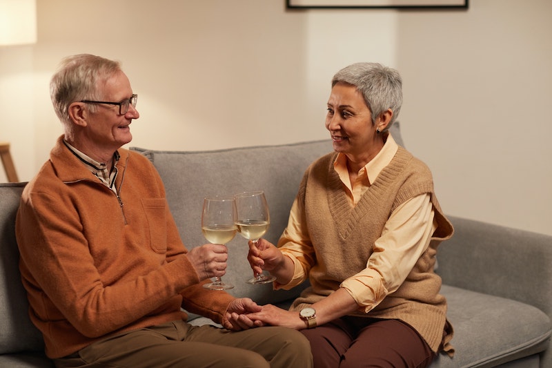 A senior couple sitting and having white wine