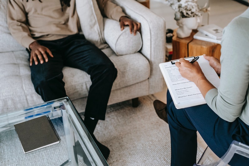 Therapist taking notes while talking to patient.