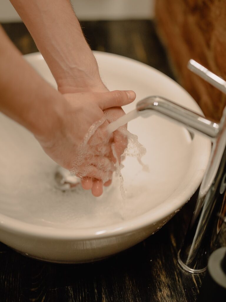 A person washing their hands in the sink