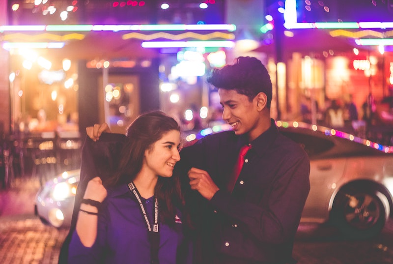 A young man and woman smile at each other.