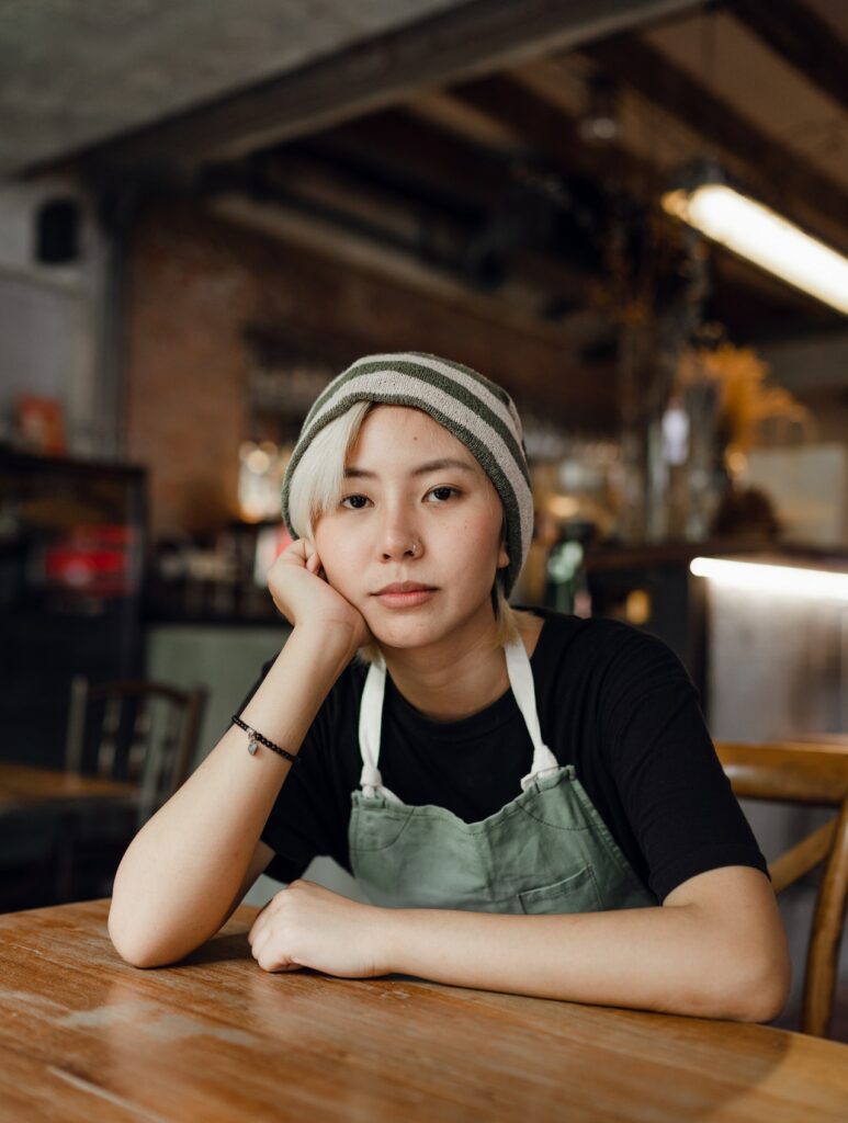 A girl with white hairs and wearing a hat sitting at a table