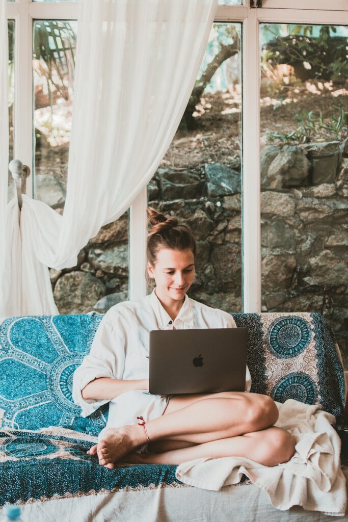 A woman smiling and looking at the laptop