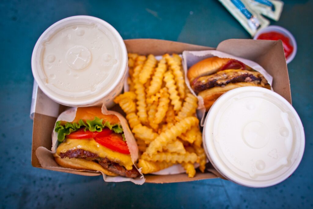 Two burgers and fries in a cardboard container.